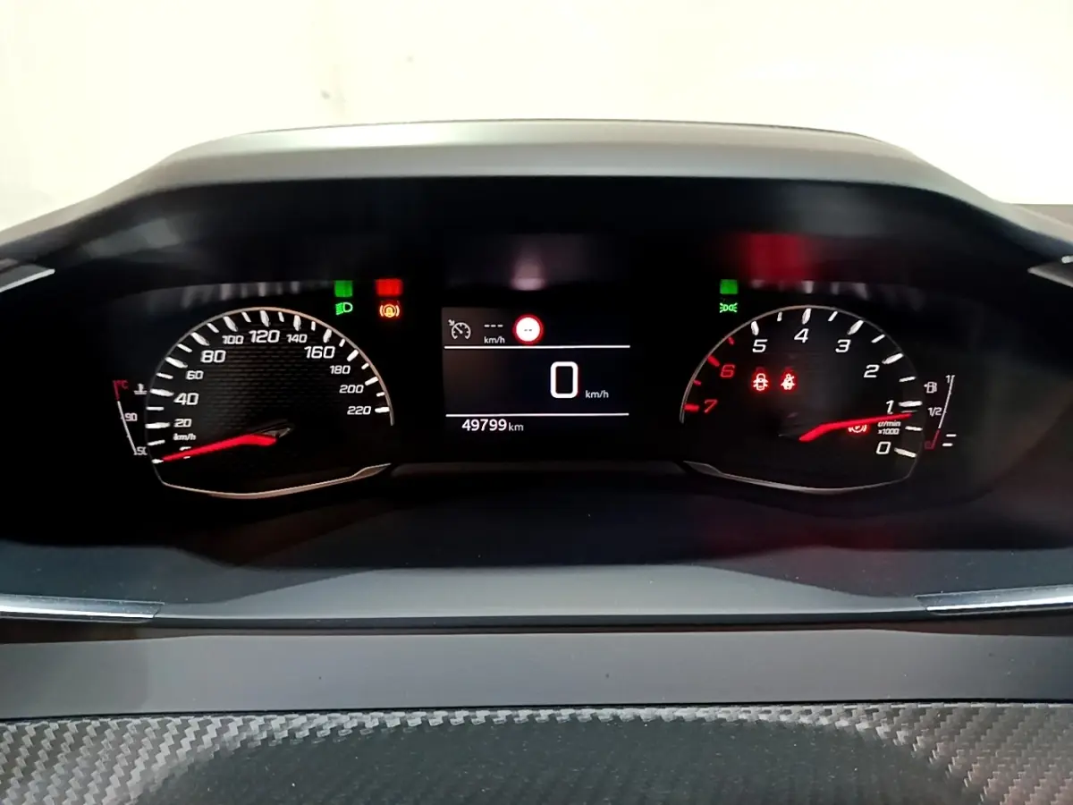 Vue rapprochée du tableau de bord numérique du Peugeot 2008 gris clair, affichant 0 km/h et 49 799 km au compteur.