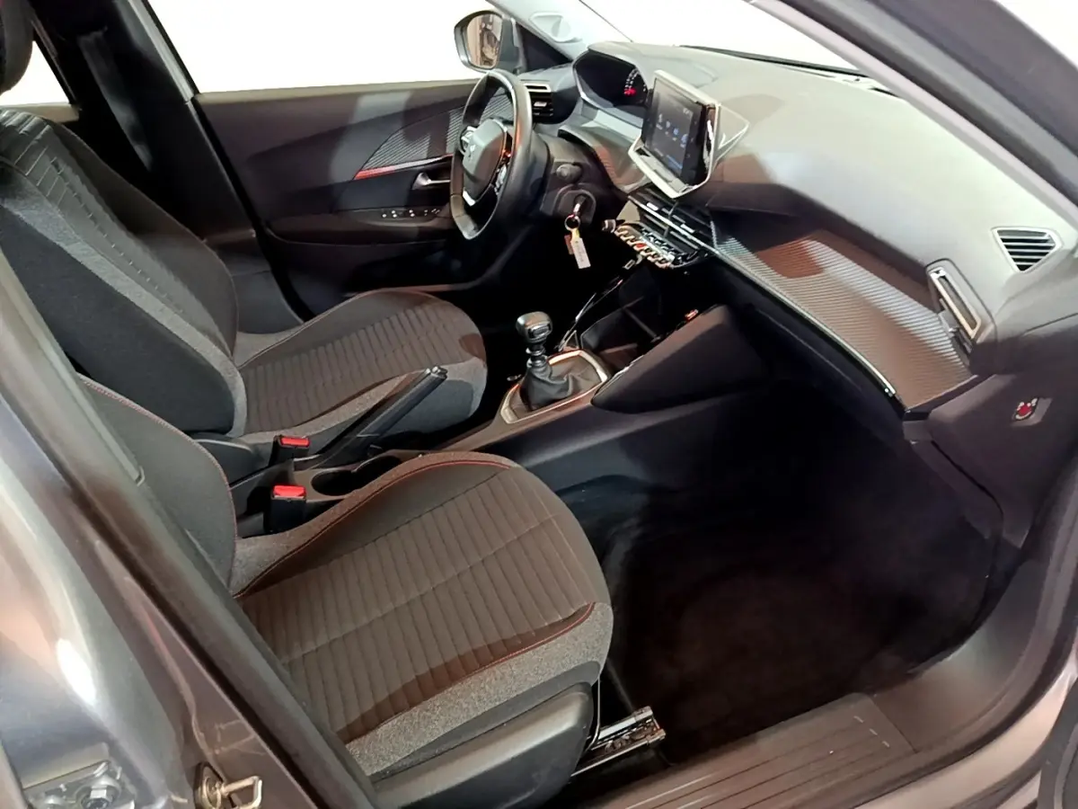 Intérieur avant droit du Peugeot 2008 gris clair 2021, avec tableau de bord moderne et écran tactile central.