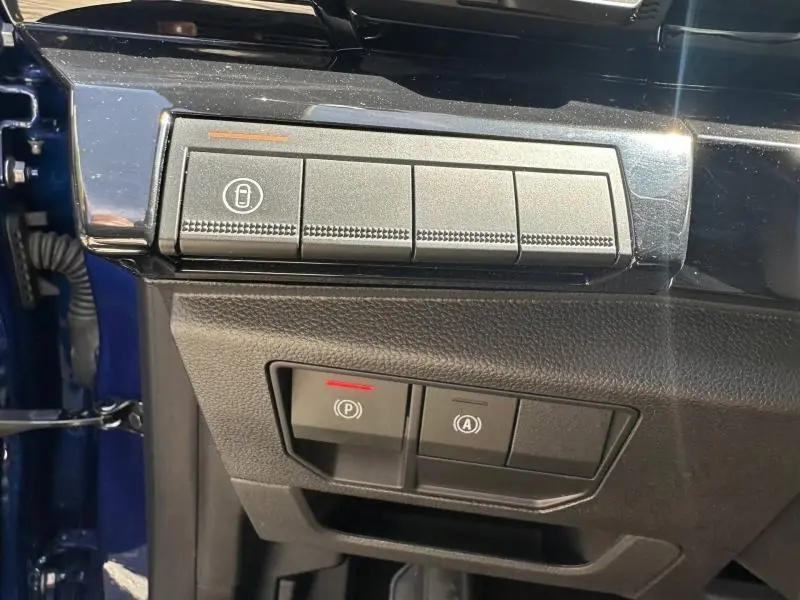 Détail des commandes de verrouillage et frein à main électrique sur le côté gauche d’un Renault Austral Bleu Iron 2025.