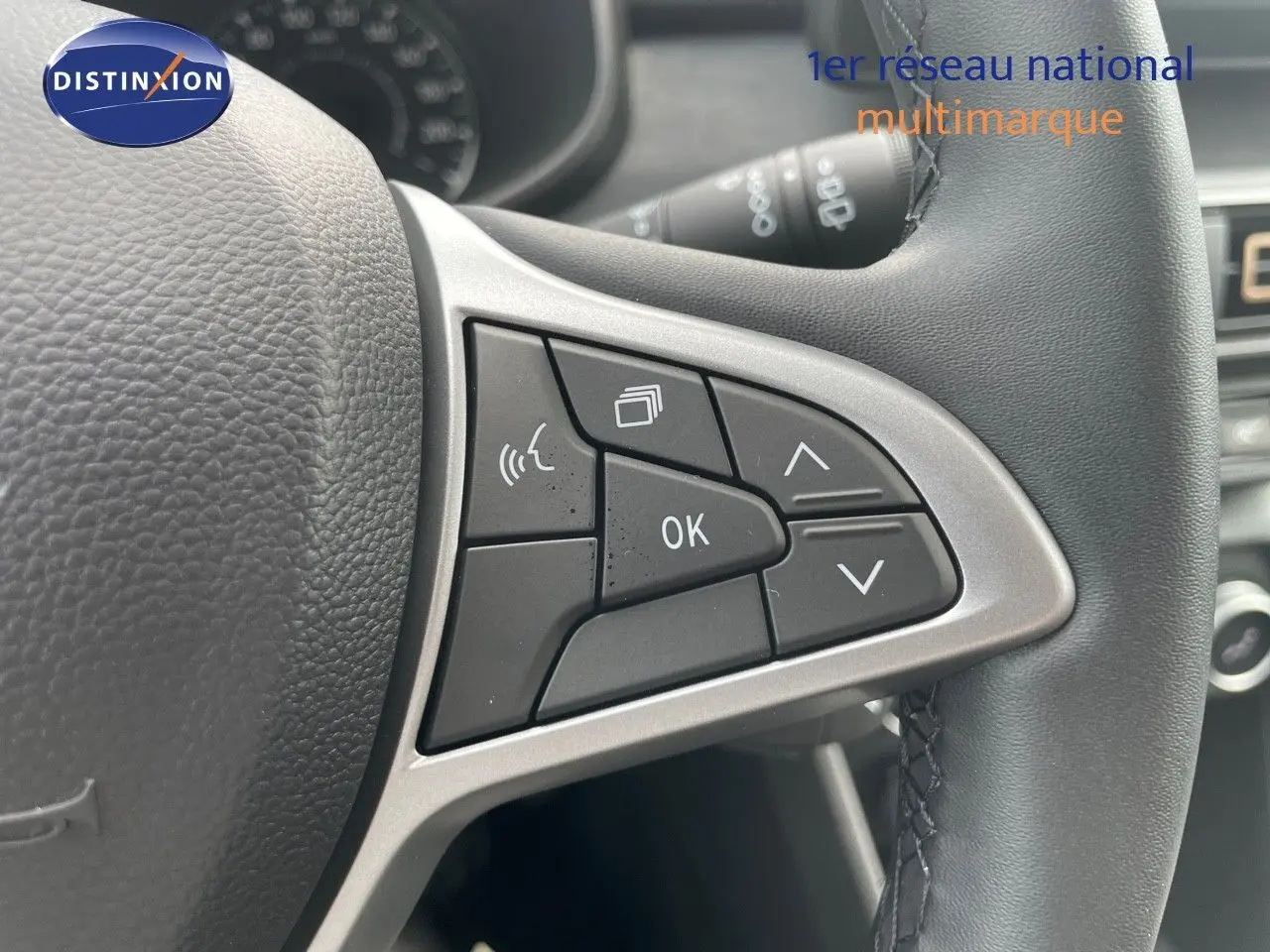 Gros plan sur les commandes multifonctions à droite du volant en cuir noir d'une Dacia Sandero Stepway 2024.
