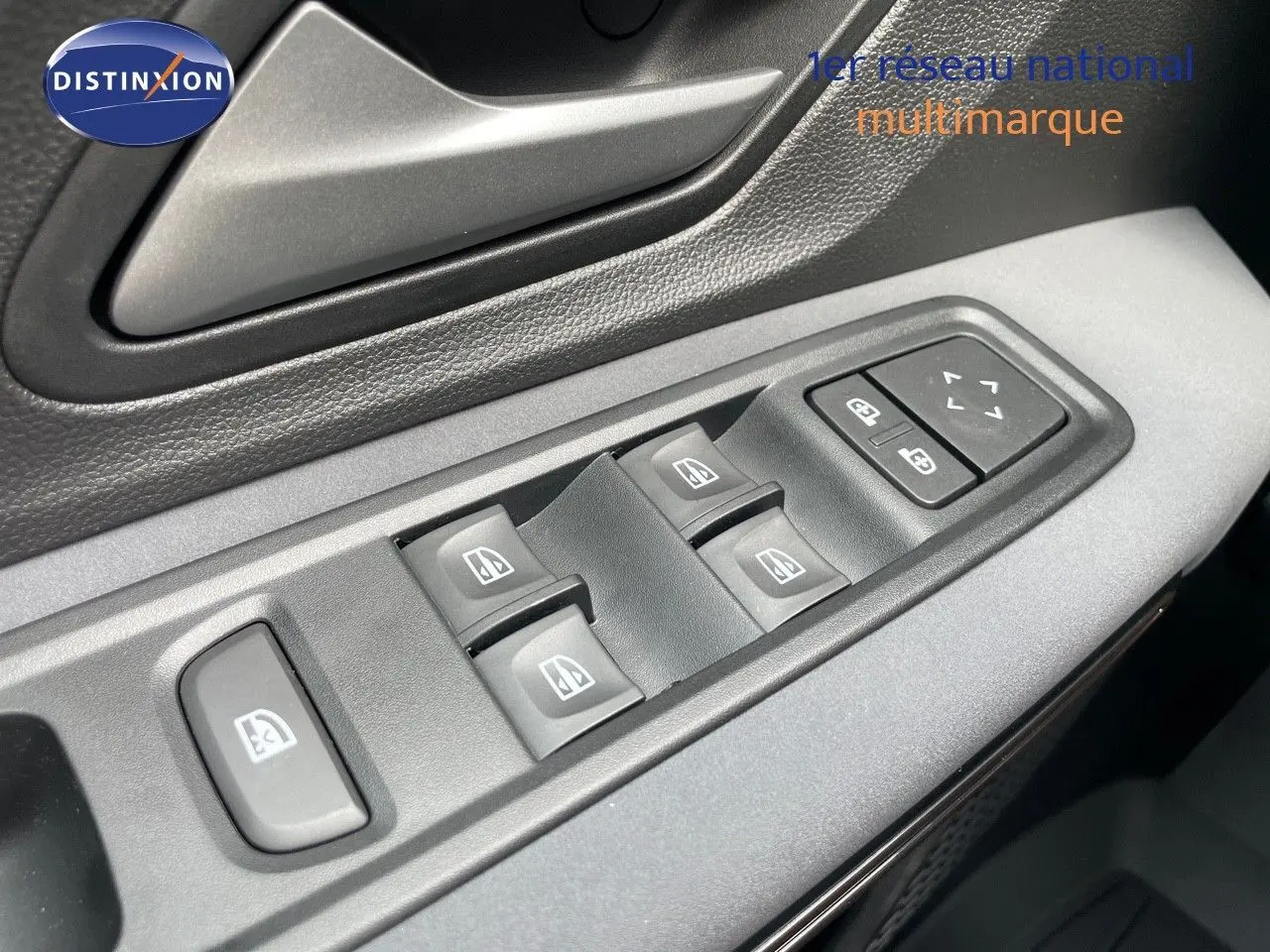 Gros plan sur les commandes des vitres électriques et rétroviseurs côté conducteur d'une Dacia Sandero Stepway 2024.