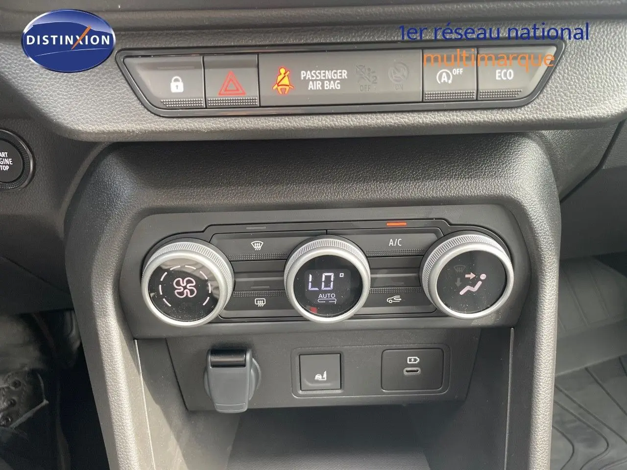 Vue rapprochée des commandes de climatisation et des boutons de sécurité du tableau de bord d'une Dacia Sandero Stepway 2024.