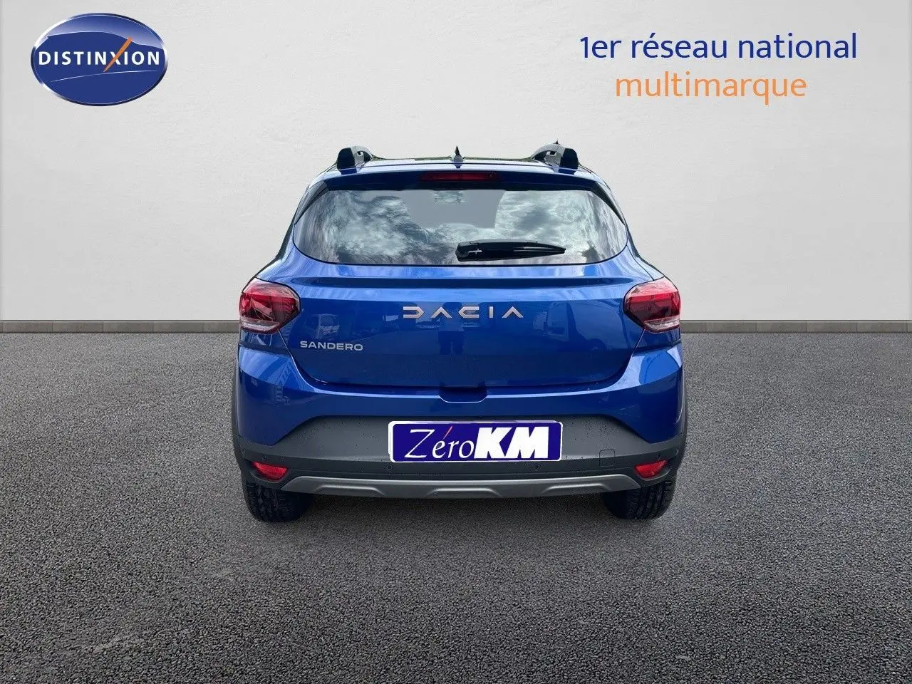 Vue arrière d'une Dacia Sandero Stepway 2024 en bleu Iron Metal avec logo et feux arrière visibles.