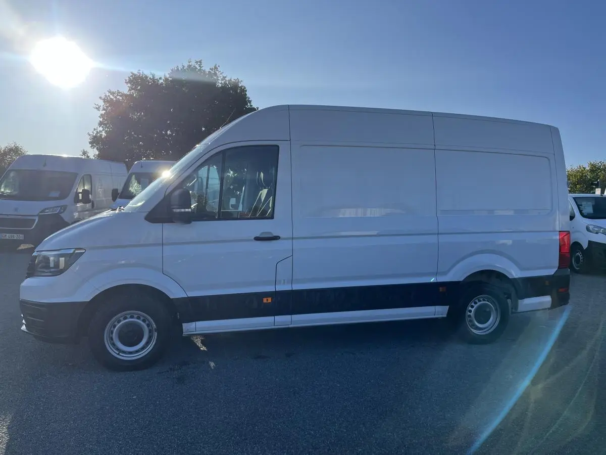 Vue latérale droite d'un Volkswagen Crafter blanc 35 L3H3 avec jantes acier et pare-chocs noirs sur parking.