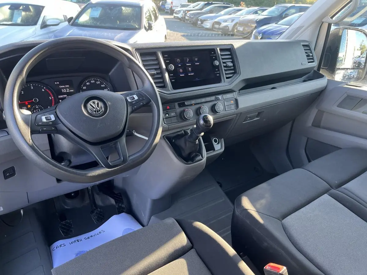 Intérieur du Volkswagen Crafter 35 L3H3 Business 2022, vue de face sur le poste de conduite et la banquette double grise.