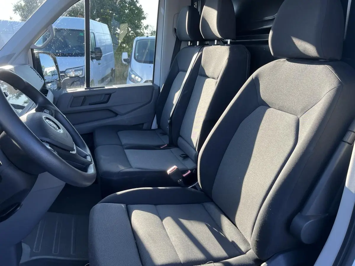 Intérieur du Volkswagen Crafter Fourgon 2022, vue côté conducteur sur banquette double en tissu gris foncé.