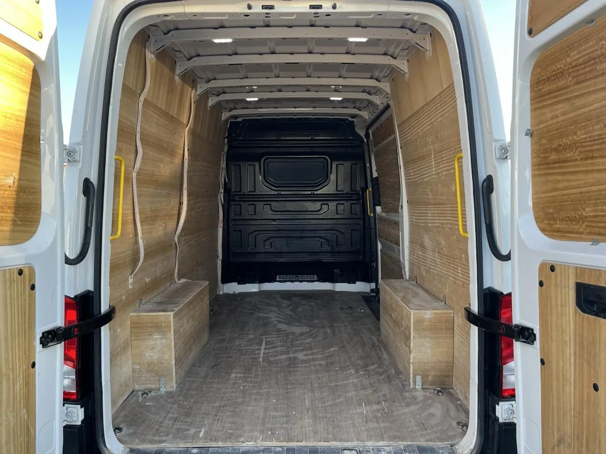 Vue arrière du Volkswagen Crafter blanc 2022, montrant l'espace de chargement avec plancher et parois en bois.