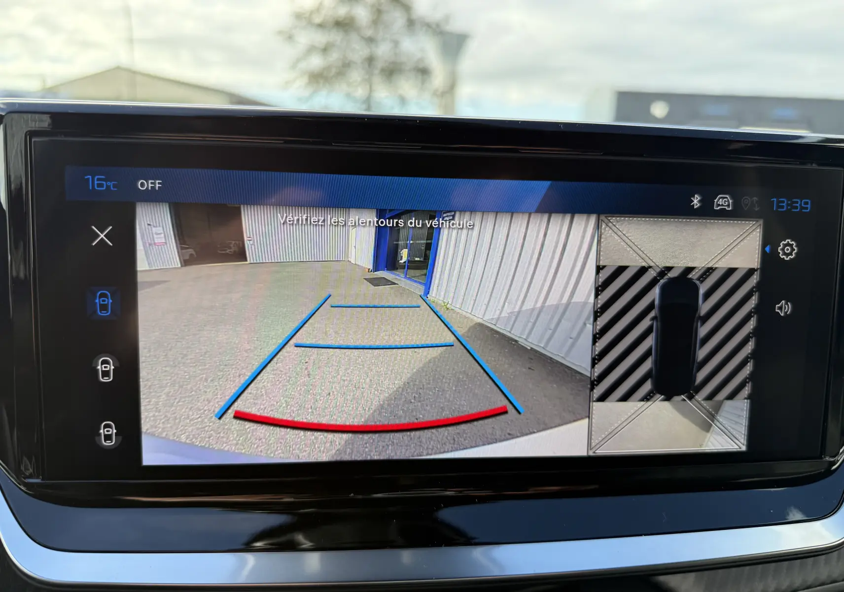 Écran de caméra de recul du Peugeot 2008 Hybrid 145ch GT, affichant les lignes de guidage et vue 360° du véhicule.