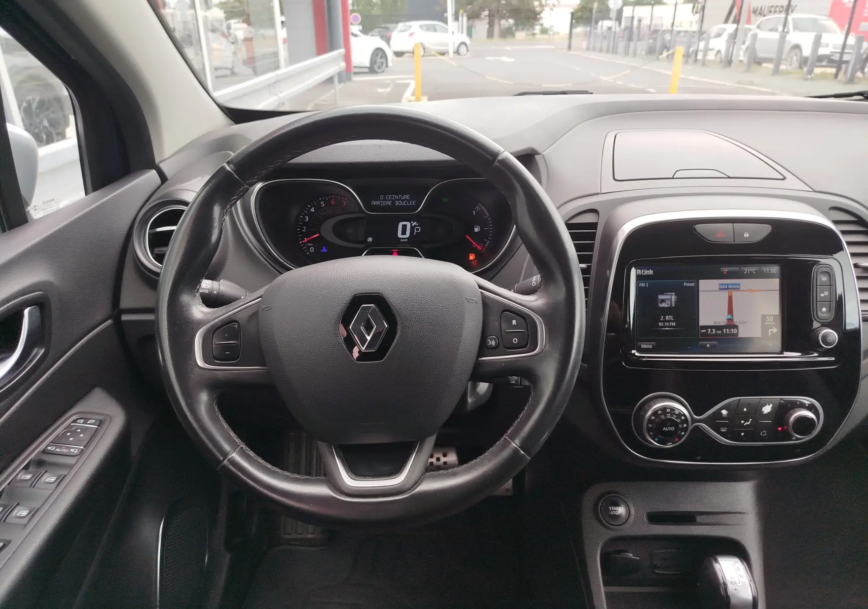Vue intérieure centrée sur le volant et le tableau de bord du Renault Captur 2018, avec écran tactile et commandes intégrées.