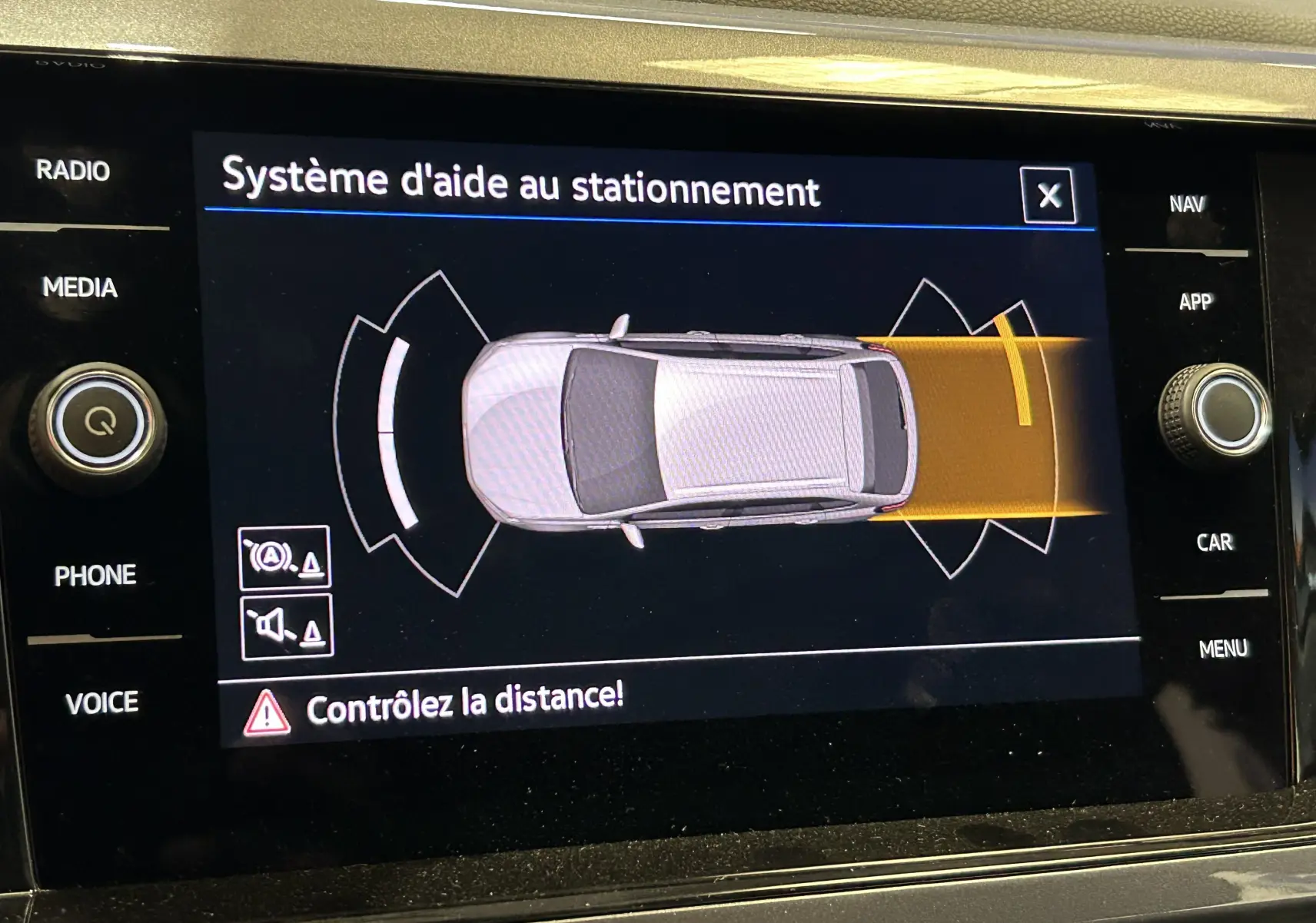 Affichage du système d'aide au stationnement du Volkswagen Taigo blanc, vue de dessus du véhicule sur l'écran tactile.