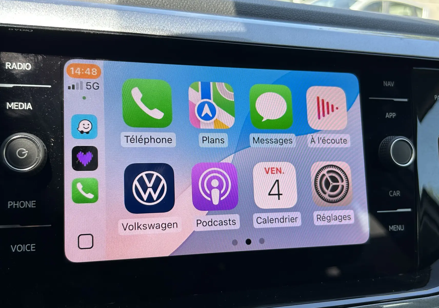 Écran tactile central du Volkswagen Taigo blanc 2022 affichant l'interface Apple CarPlay avec applications connectées.