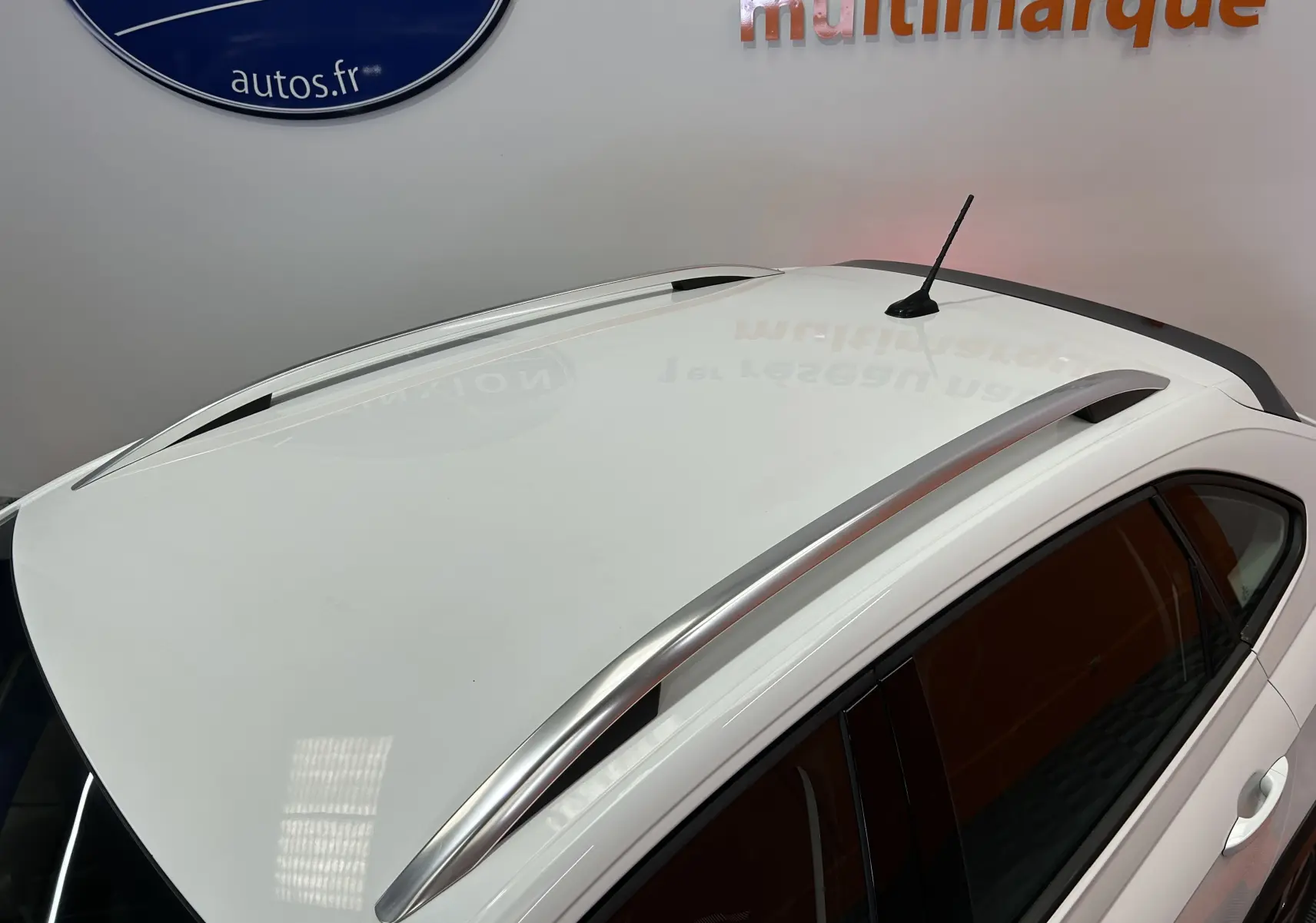 Toit blanc pur du Volkswagen Taigo TSI 110 DSG7 Style 2022 avec barres de toit argentées vues en plongée.