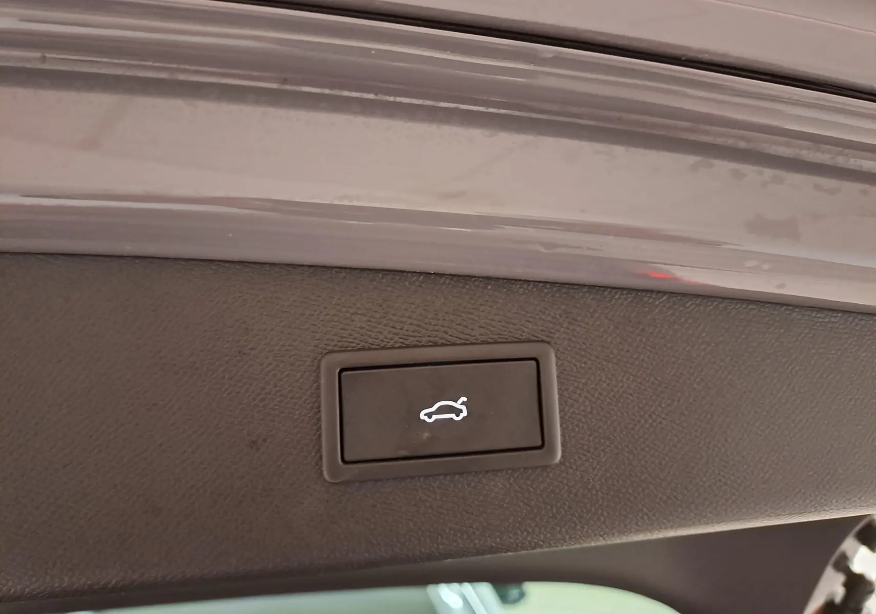 Bouton d'ouverture électrique du coffre sur la partie intérieure du hayon d'une CUPRA Leon ST gris Graphène.