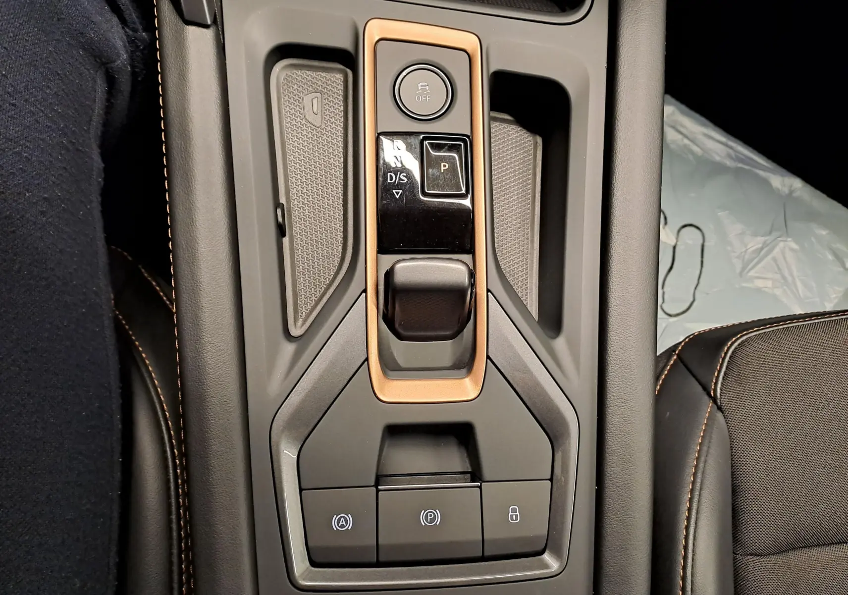 Vue plongeante sur la console centrale de la CUPRA LEON ST 2025 avec levier de vitesses et finitions cuivrées.