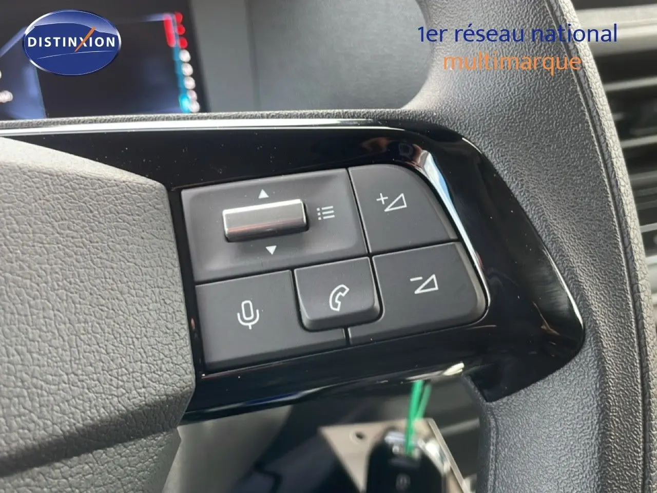 Gros plan sur les commandes au volant du Citroën Jumpy gris titane, boutons de volume et téléphone visibles.