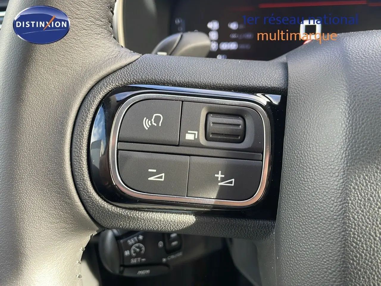 Gros plan sur les commandes du volant du Citroën C5 Aircross 2025 en cuir noir, mettant en valeur les boutons de réglage audio.