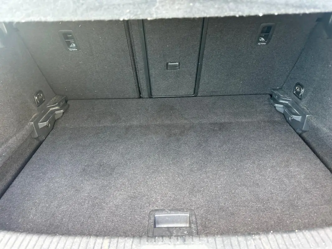 Coffre spacieux et propre de la Volkswagen Golf 1.5 TSI noir, vue intérieure depuis l'ouverture arrière.