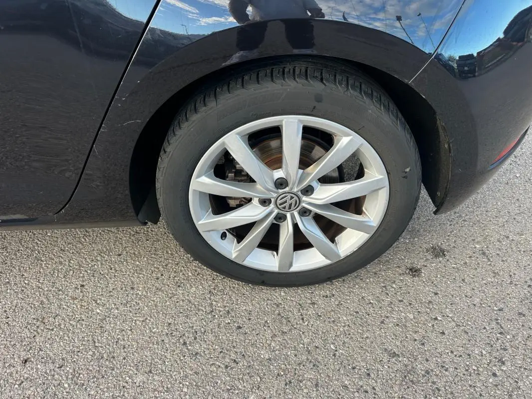 Gros plan sur la roue arrière droite noire d'une Volkswagen Golf 1.5 TSI avec jante alliage 17 pouces.