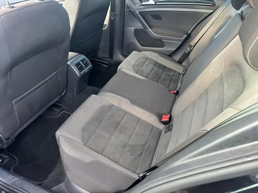 Vue intérieure côté droit des sièges arrière en tissu gris et noir d'une Volkswagen Golf 1.5 TSI noire de 2018.
