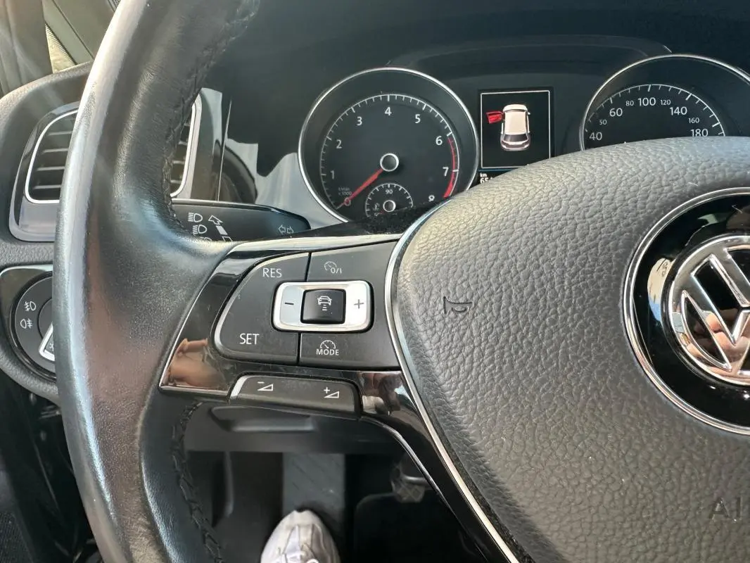 Gros plan sur le volant multifonctions noir de la Volkswagen Golf 1.5 TSI 2018 avec tableau de bord et commandes visibles.