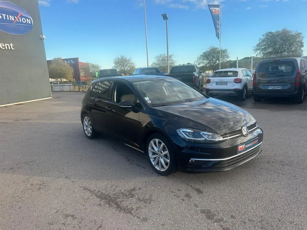 Volkswagen Golf noire vue en 3/4 avant droit, avec jantes alliage 17 pouces et phares LED visibles.