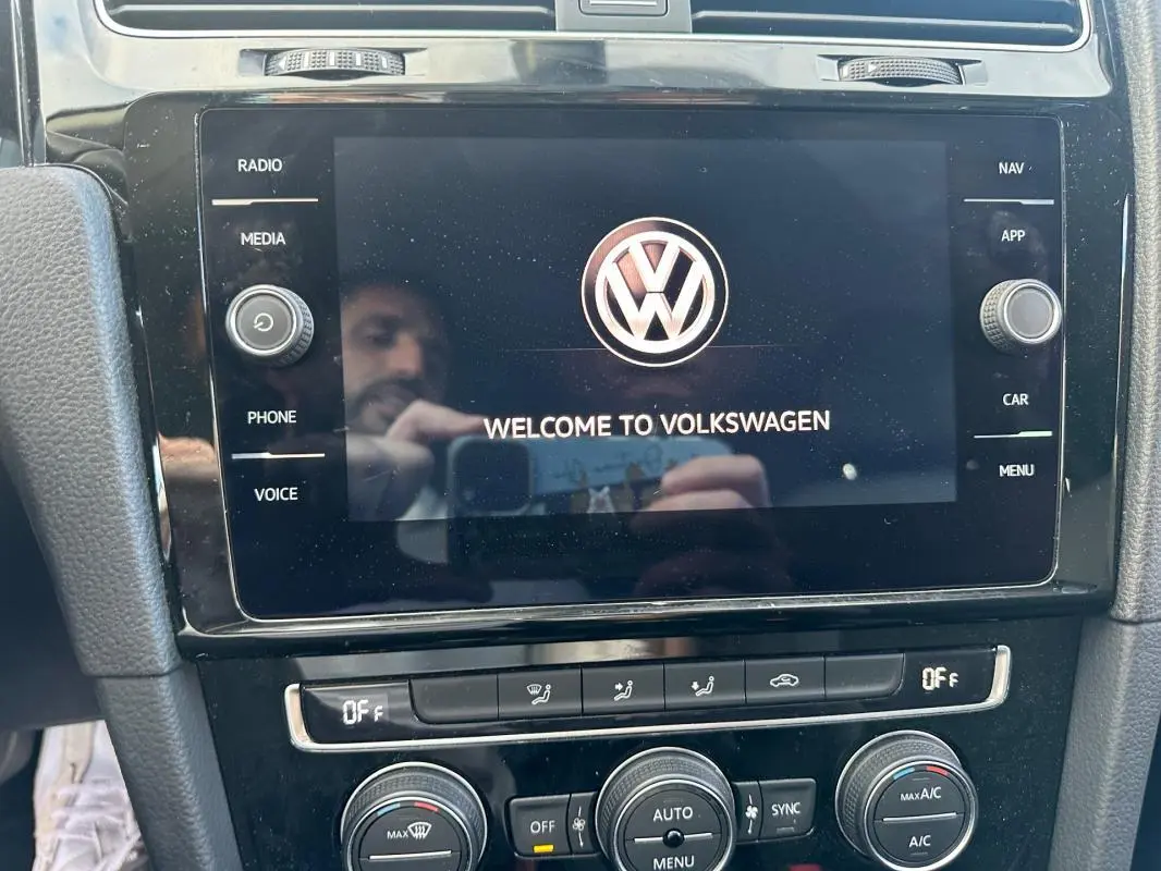 Écran tactile central allumé avec logo Volkswagen dans l'habitacle noir d'une Golf 1.5 TSI 2018.
