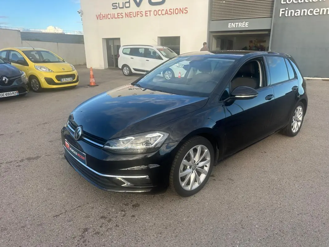 Volkswagen Golf noir vue en 3/4 avant droit avec jantes alliage 17 pouces sur parking extérieur.