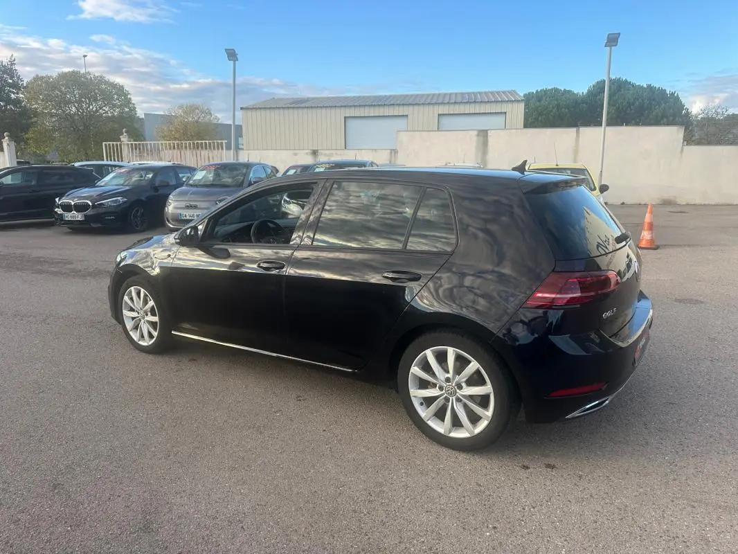 Volkswagen Golf noire vue de trois quarts arrière droit, avec jantes alliage 17 pouces et toit ouvrant électrique.