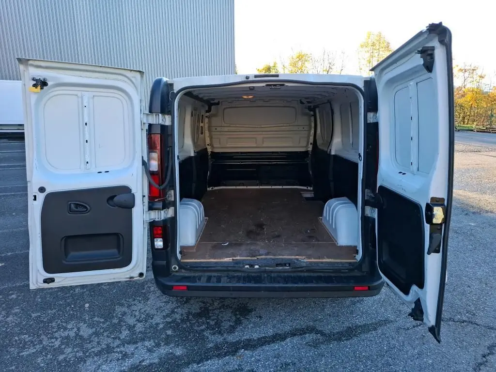 Vue arrière ouverte du Renault Trafic Fourgon blanc L2H1 2019 montrant l'espace de chargement vide avec plancher en bois.