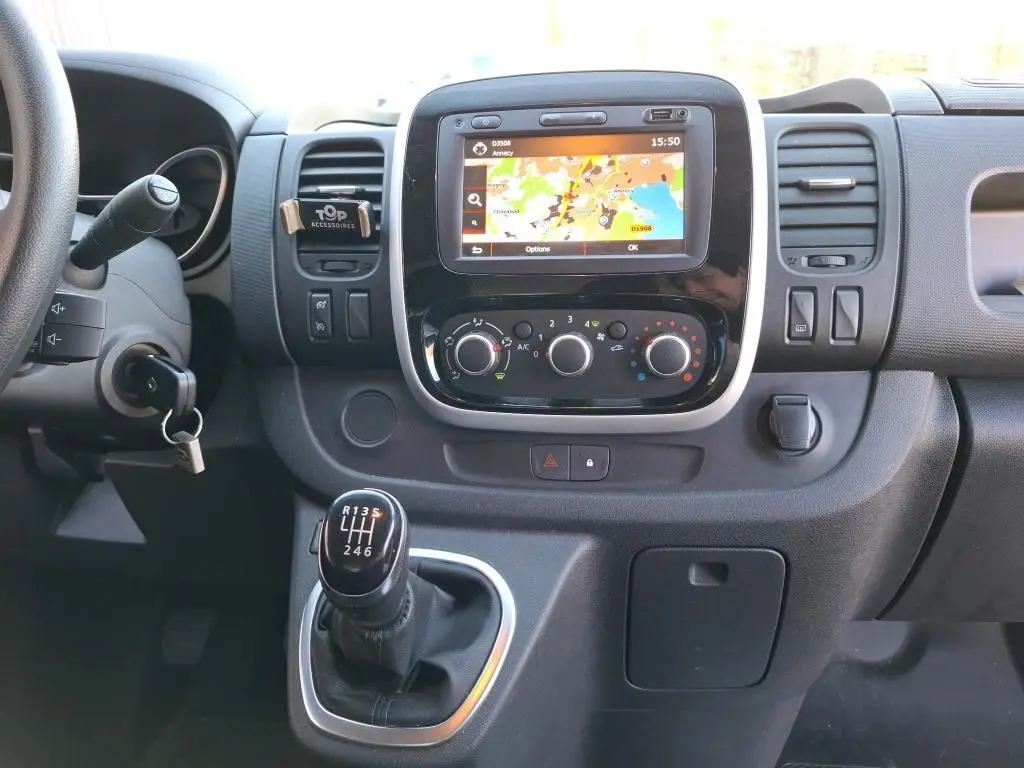 Vue rapprochée du tableau de bord du Renault Trafic Fourgon blanc 2019, avec écran GPS et levier de vitesses manuel.