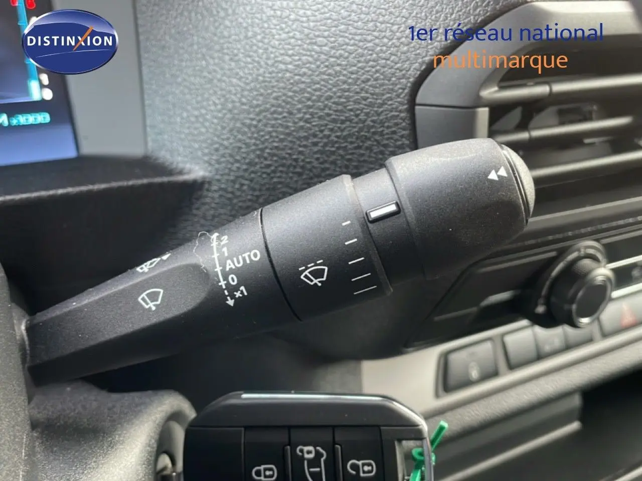 Gros plan sur la commande d’essuie-glace à gauche du volant dans l’habitacle gris d’un Citroën Jumpy gris titane.