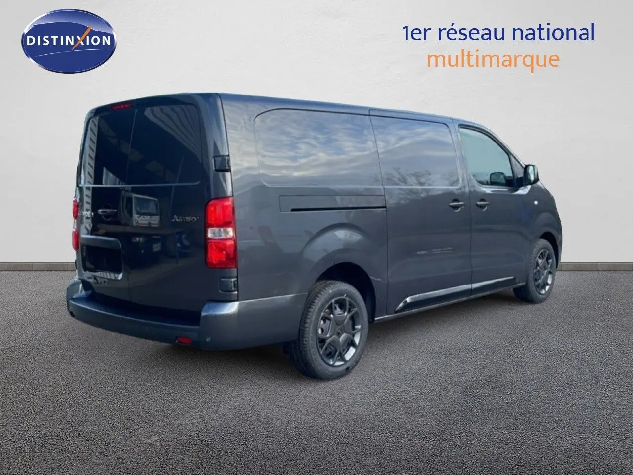 Vue 3/4 arrière droite d’un Citroën Jumpy Van Long gris titane métallisé avec portes latérales et arrière fermées.