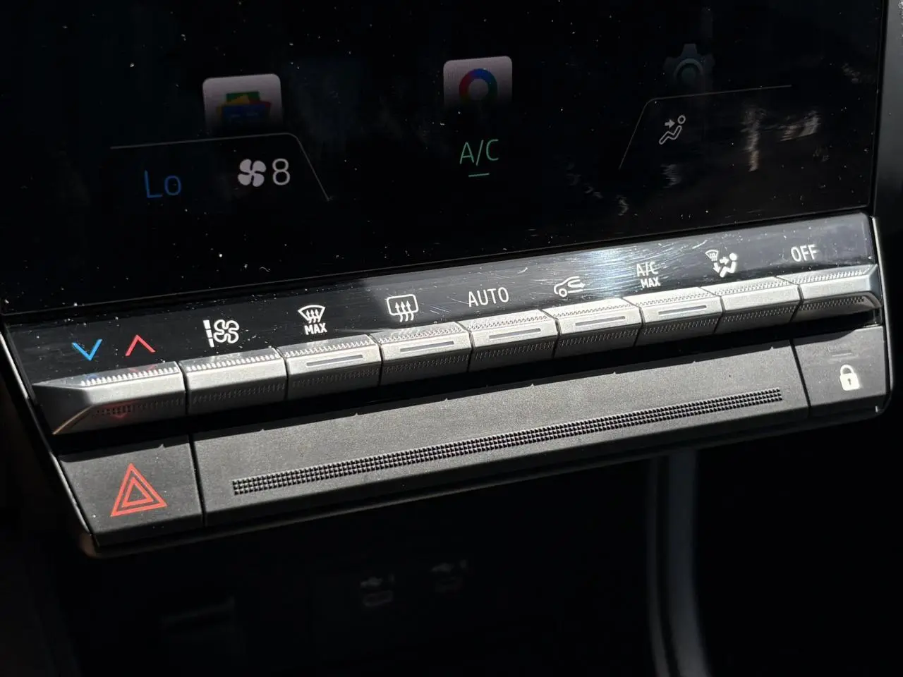 Gros plan sur la console centrale du Renault Captur 2025, boutons de climatisation et verrouillage visibles.