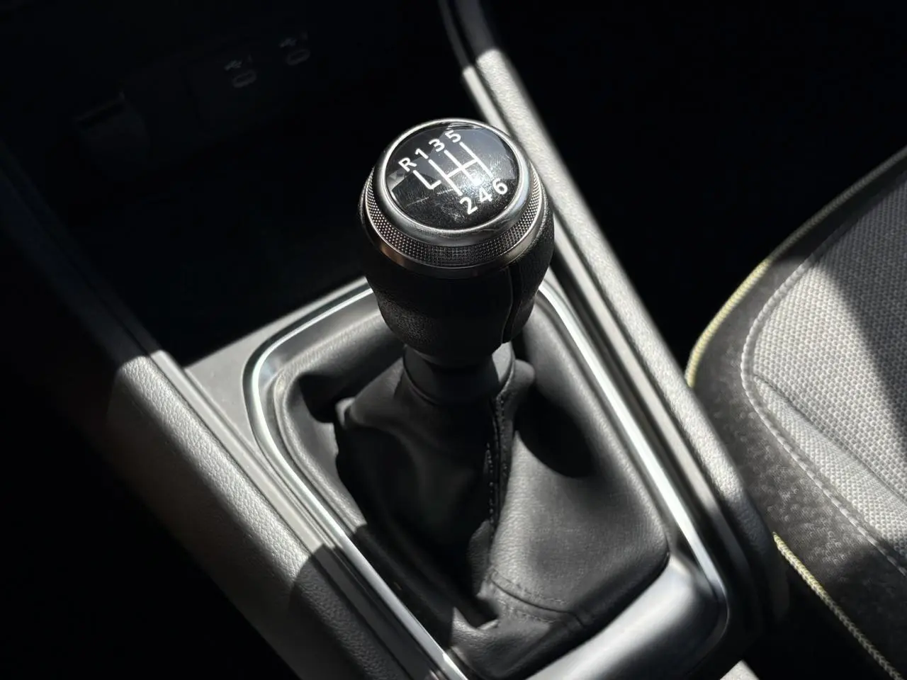 Le levier de vitesses manuel noir du Renault Captur TCE 90 Techno, vu en gros plan depuis l'intérieur.