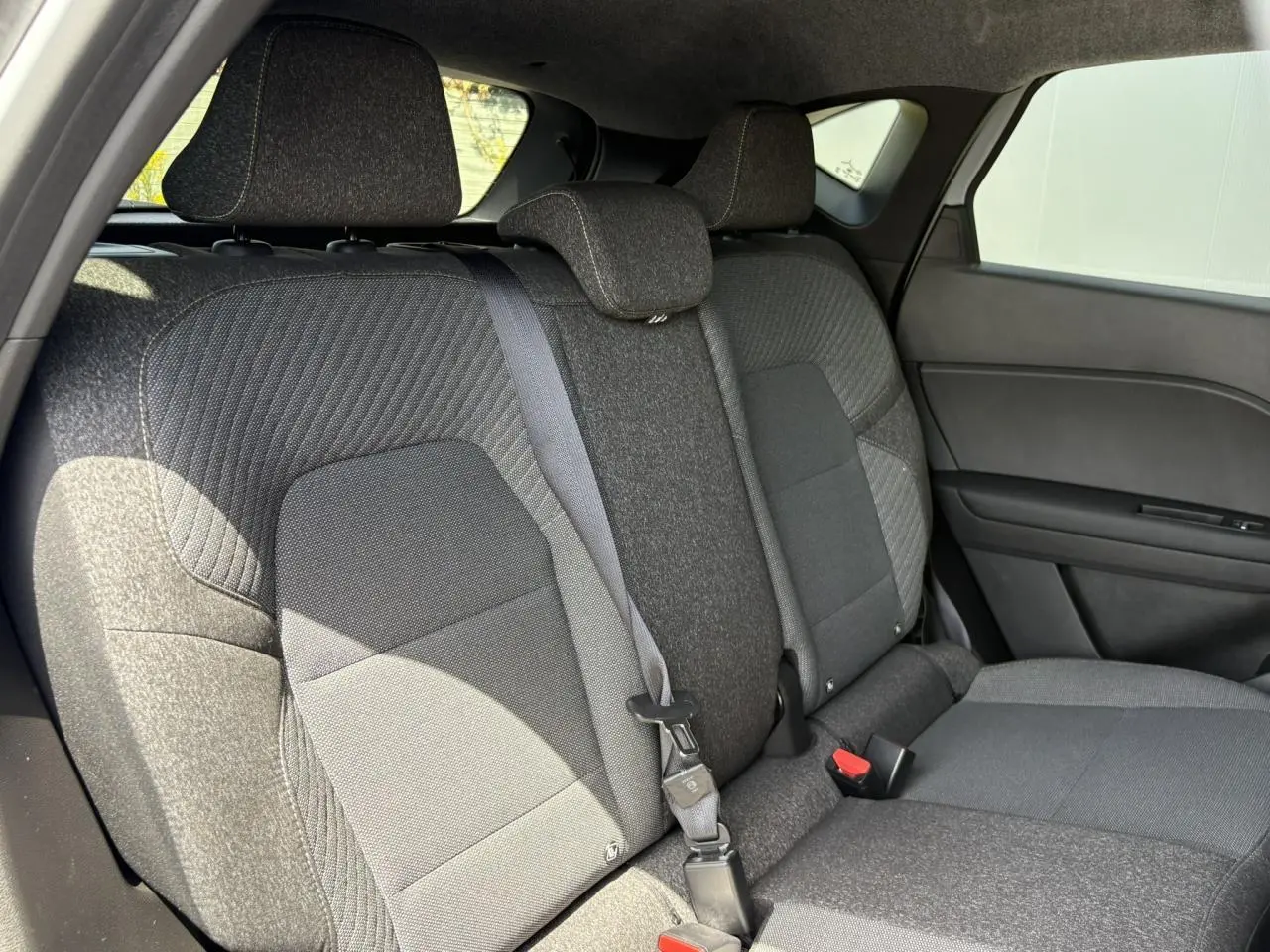Vue latérale droite des sièges arrière gris foncé du Renault Captur TCE 90 Techno 2025 avec ceinture de sécurité visible.