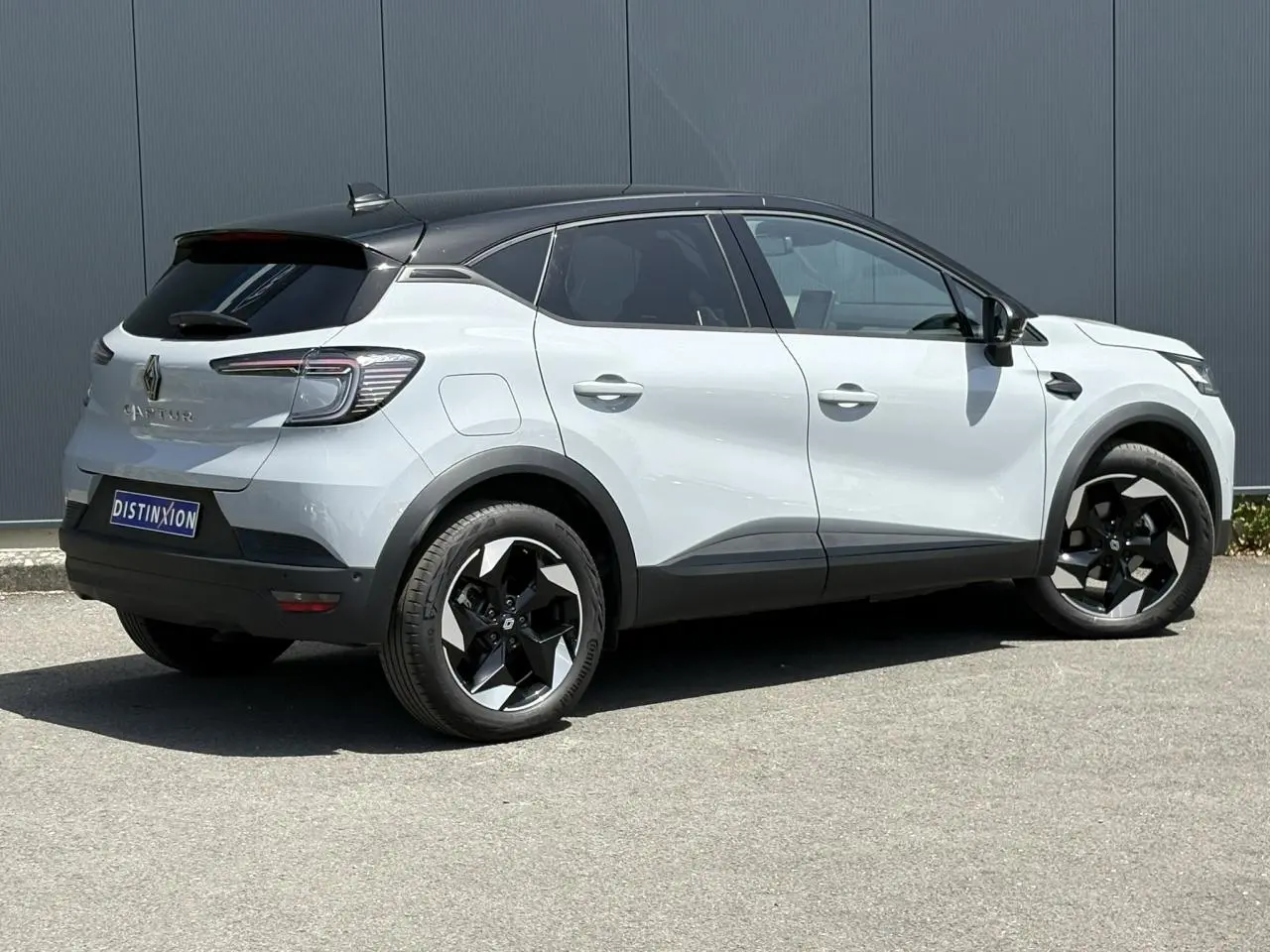 Vue 3/4 arrière droite du Renault Captur 2025 gris Rafale avec toit noir étoilé et jantes noires.