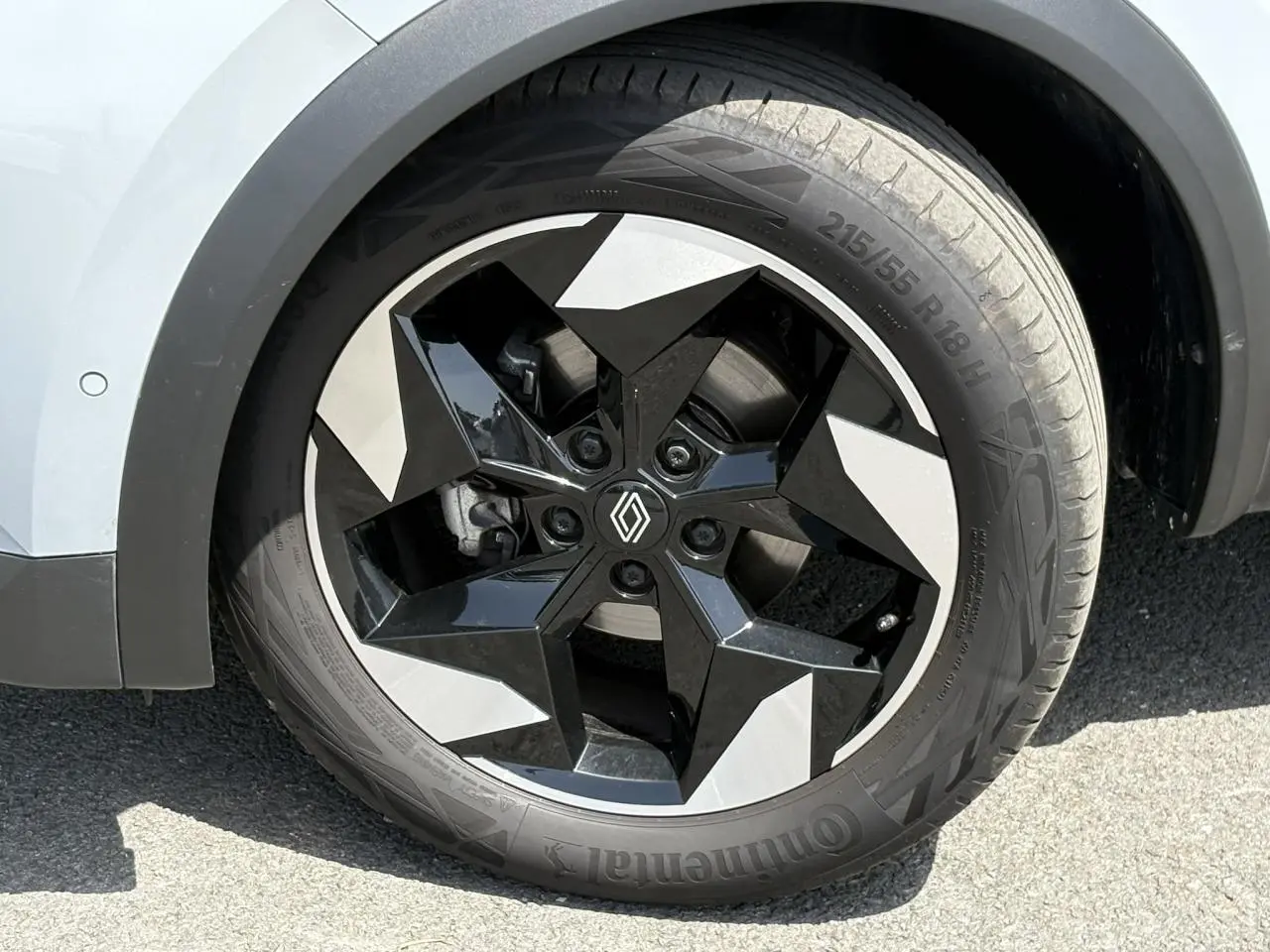 Gros plan sur la roue avant gauche du Renault Captur 2025, jante aluminium 18 pouces bicolore noir et gris.
