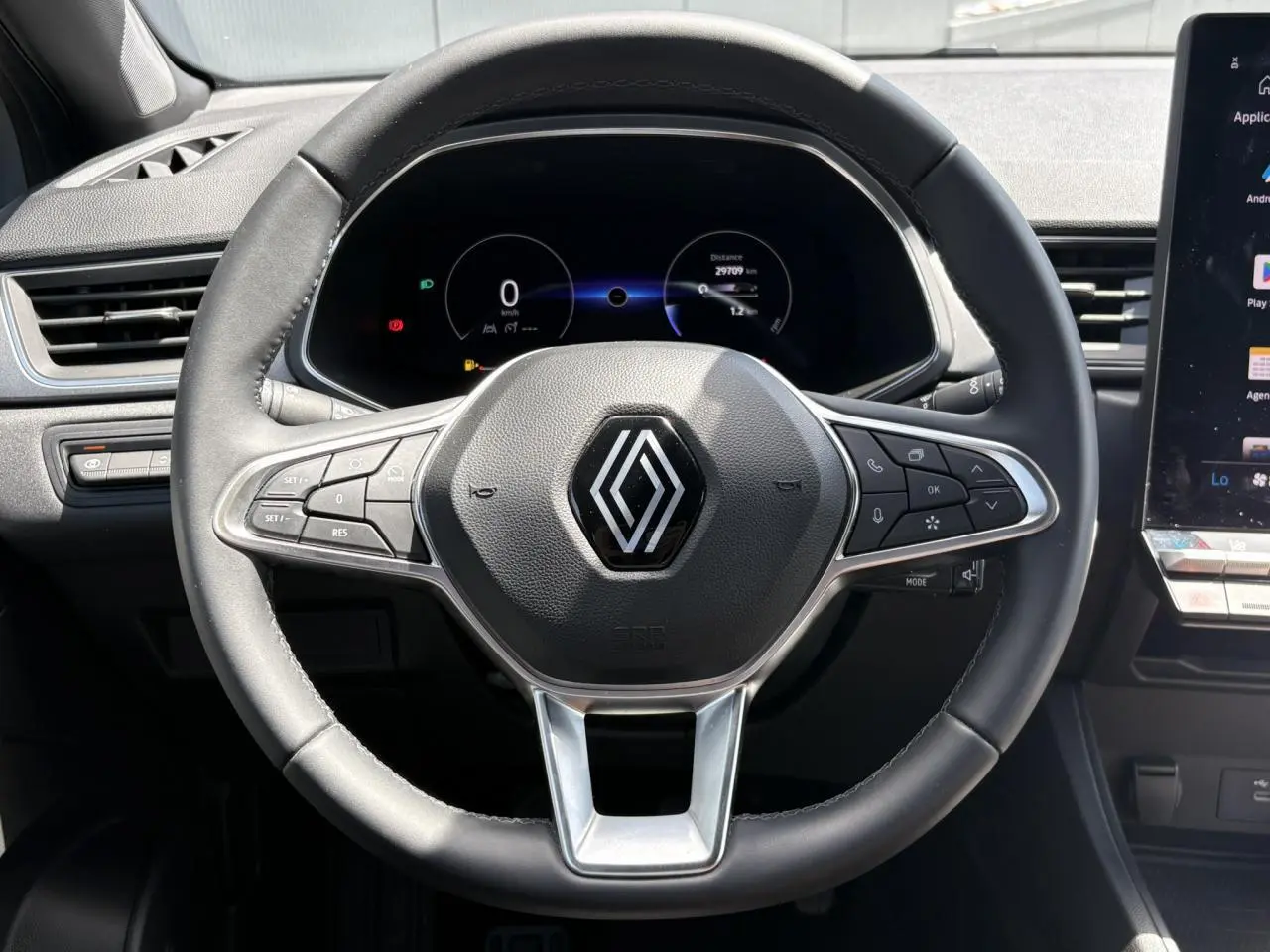 Vue centrée sur le volant noir du Renault Captur 2025 avec tableau de bord numérique et commandes intégrées.
