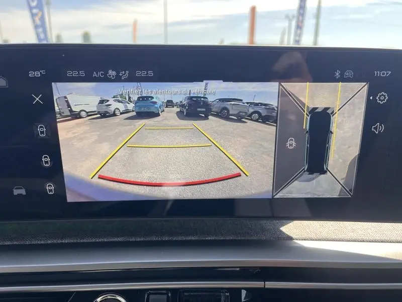 Écran tactile intérieur du Peugeot 5008 Hybrid blanc montrant la caméra de recul et vue 360° du véhicule en stationnement.