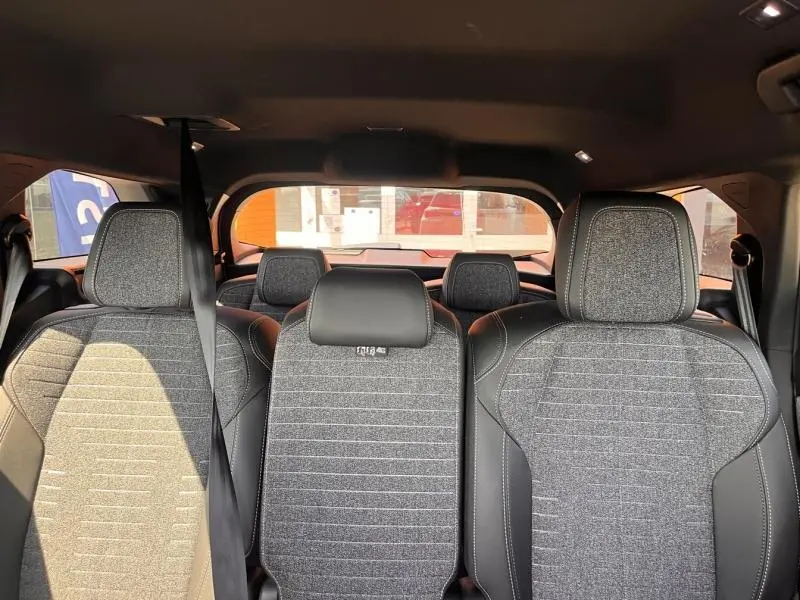 Vue intérieure arrière des sièges gris texturés du Peugeot 5008 Hybrid 145ch Allure e-DCS6, montrant les trois rangs de sièges.