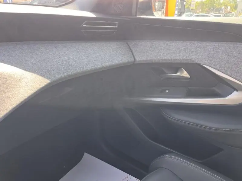 Vue intérieure côté passager du Peugeot 5008 Hybrid 145ch Allure e-DCS6 2025, avec garniture tissu gris et panneaux noirs.