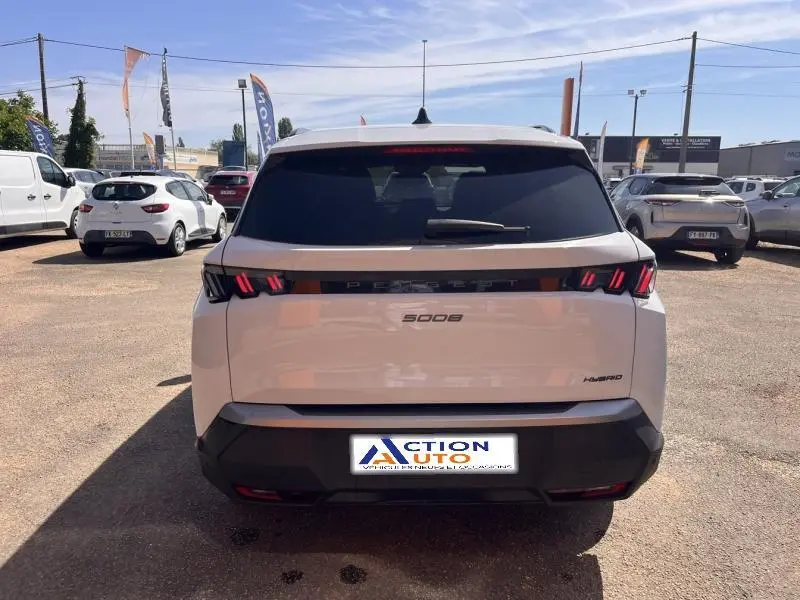 Vue arrière d'un Peugeot 5008 Hybrid blanc Okénite avec feux LED caractéristiques et lunette arrière surteintée.