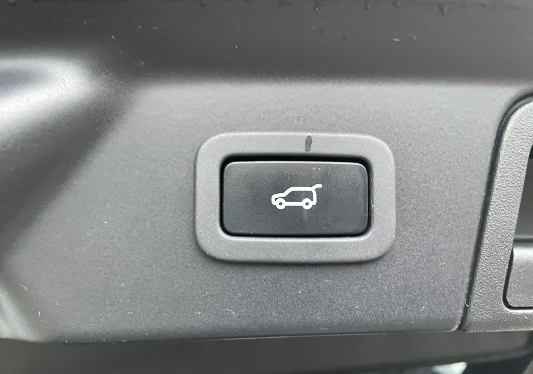Bouton de commande intérieur pour l'ouverture électrique du coffre sur Range Rover Velar D300 gris Silicon Silver.