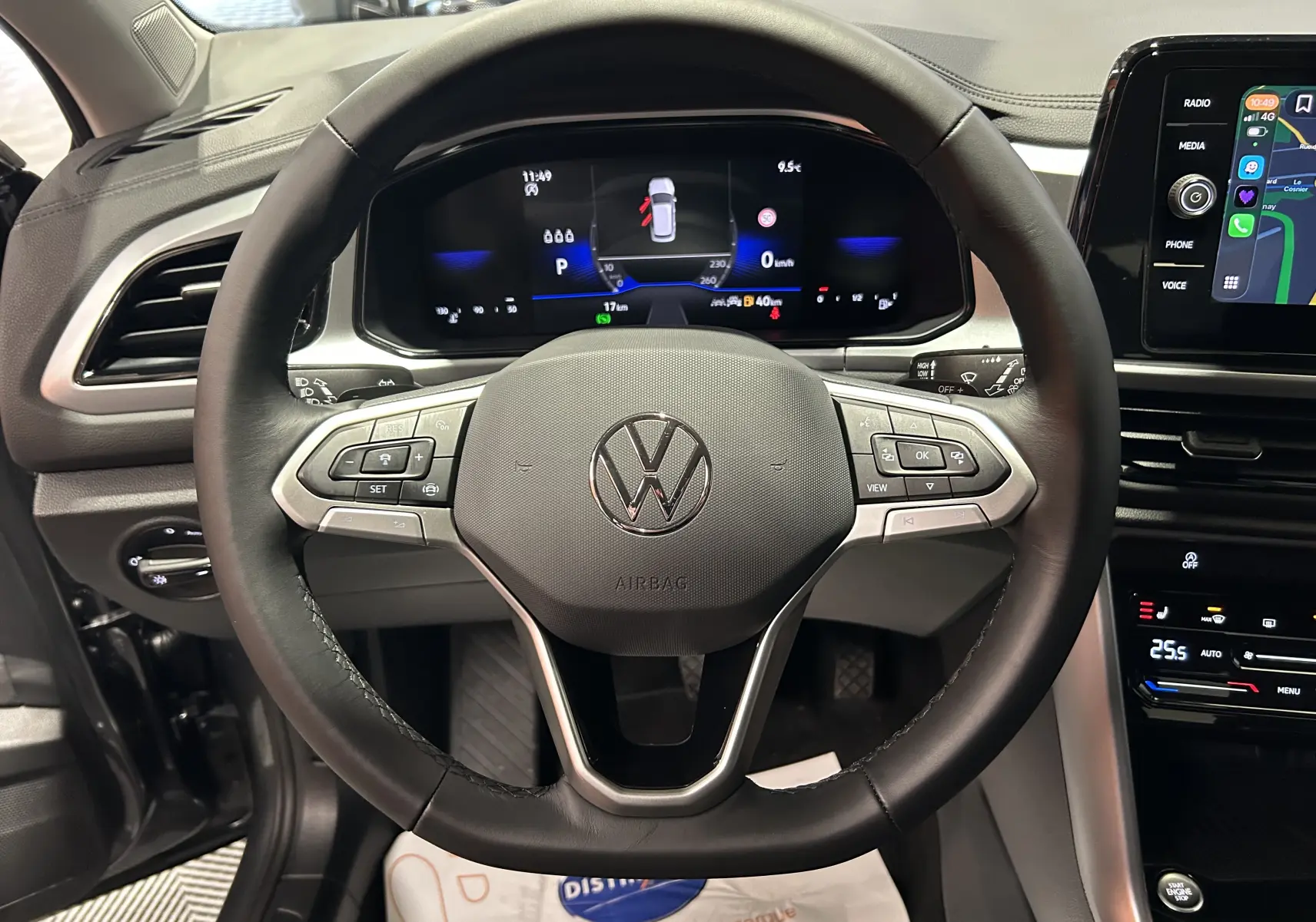 Vue centrée sur le volant noir du Volkswagen T-Roc 2025 avec tableau de bord digital et écran tactile à droite.