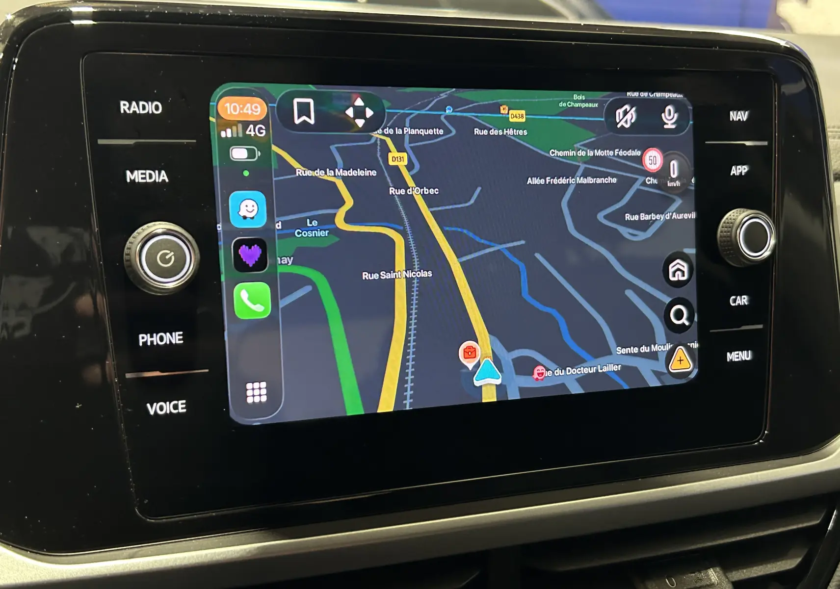 Écran tactile central du Volkswagen T-Roc 2025 affichant la navigation avec commandes tactiles et boutons latéraux.