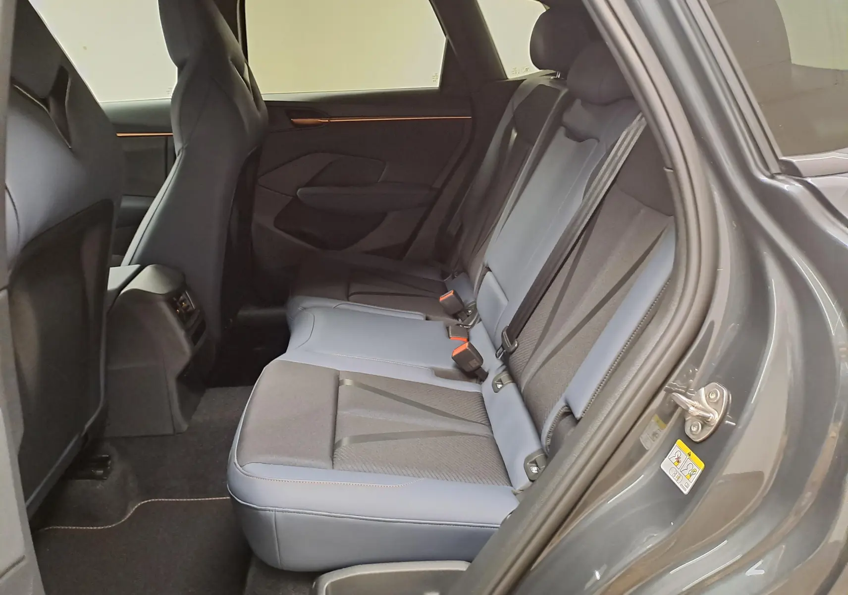 Vue côté droit de l'habitacle arrière du CUPRA TERRAMAR gris Timanfaya avec sièges en cuir et tissu bicolore.