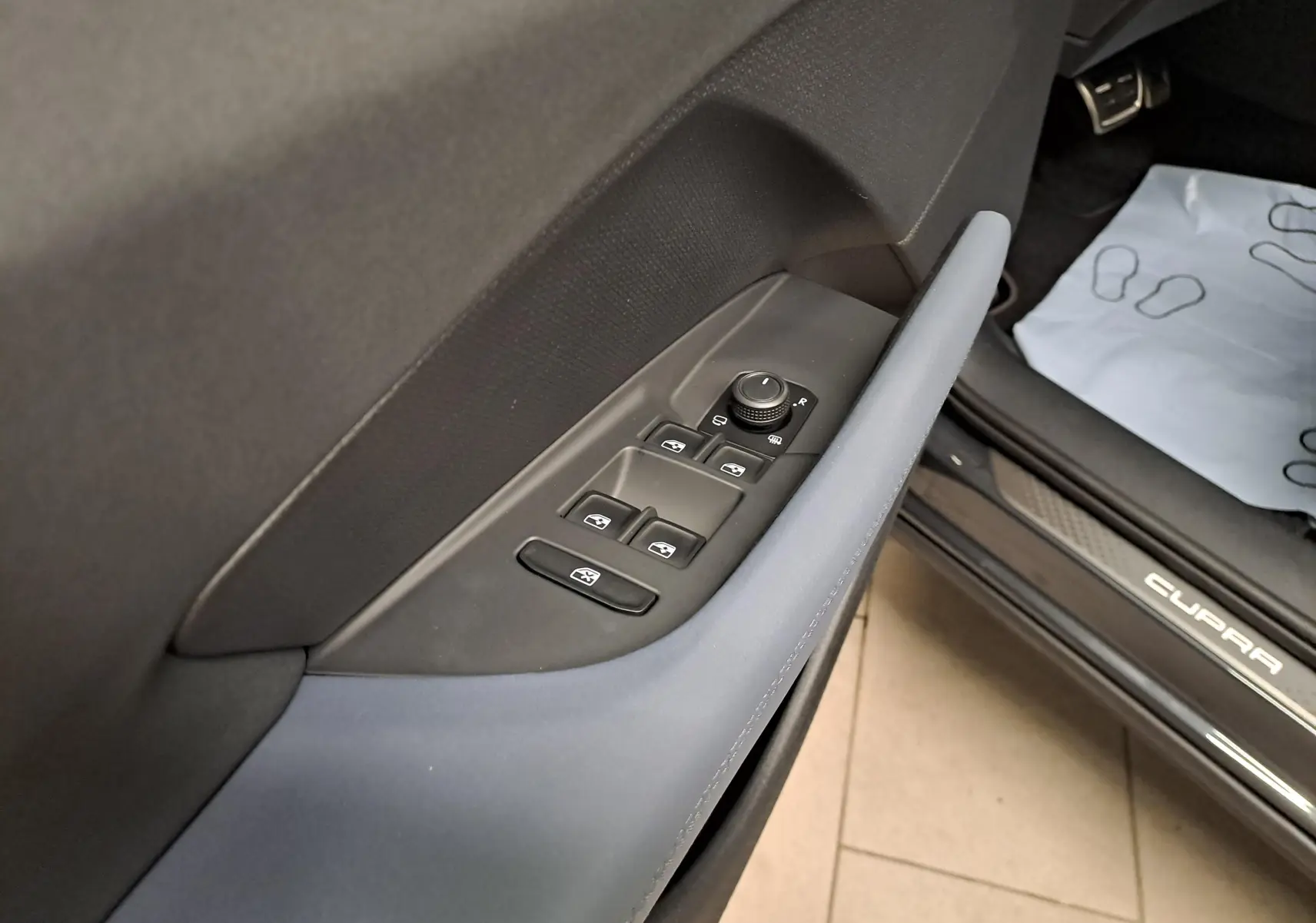 Gros plan sur la porte côté conducteur du CUPRA TERRAMAR 2025, avec commandes de vitres et seuil de porte marqué CUPRA.