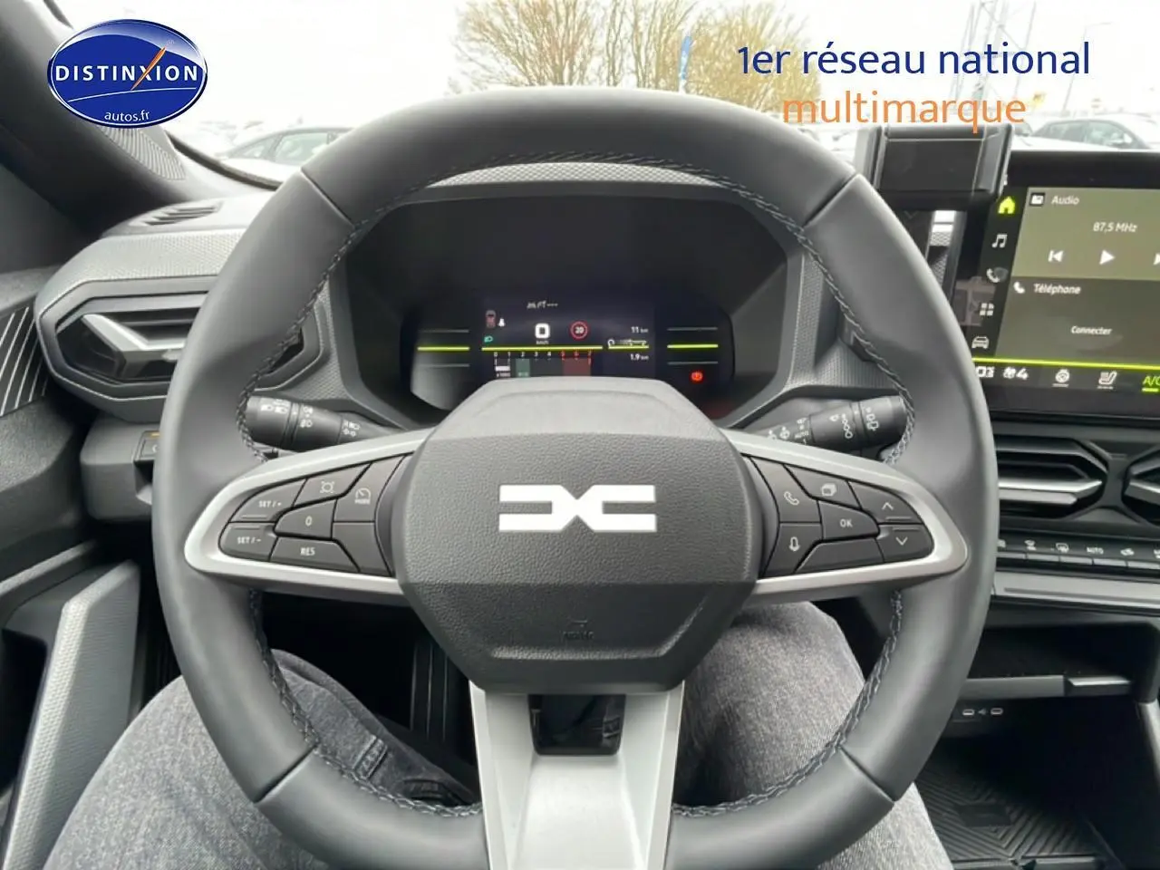 Vue intérieure centrée sur le volant multifonction du Dacia Duster 2026 avec écran tactile et tableau de bord numérique.