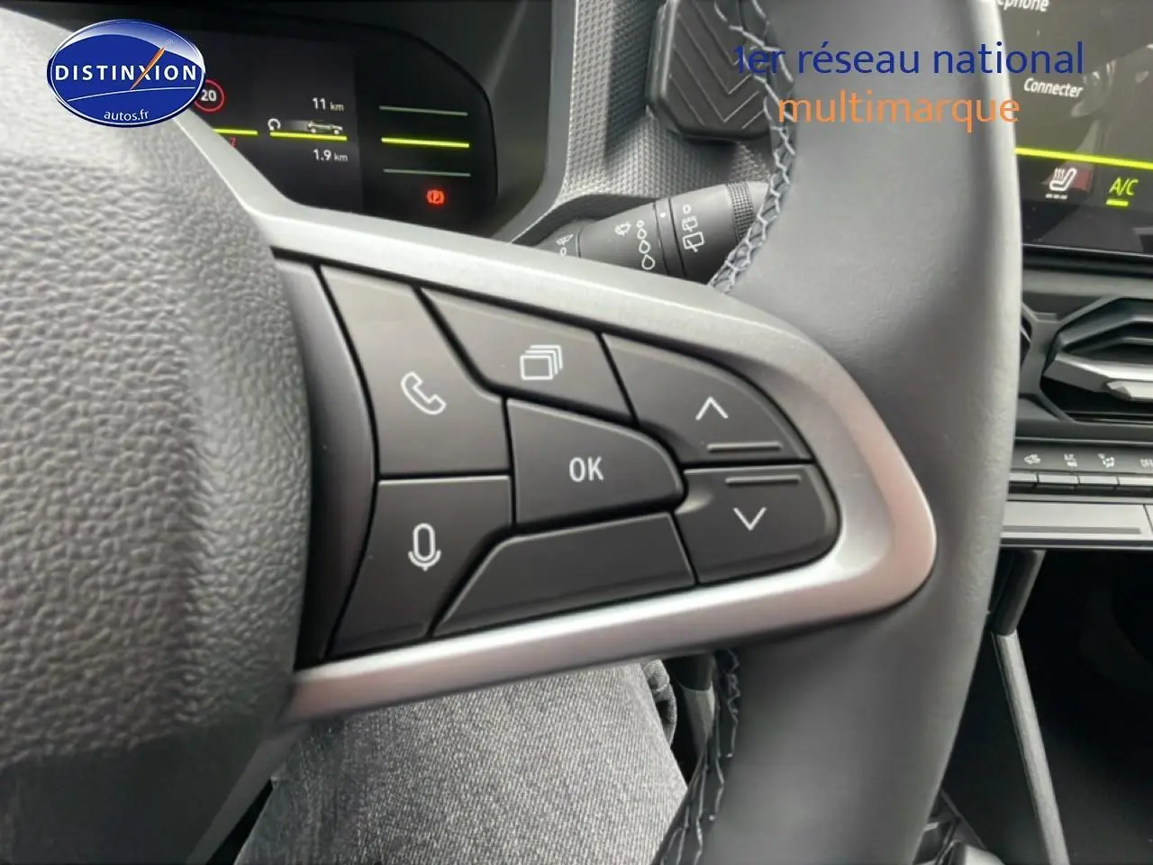 Gros plan sur les commandes multifonctions noires du volant du Dacia Duster 2026, intérieur gris et noir.