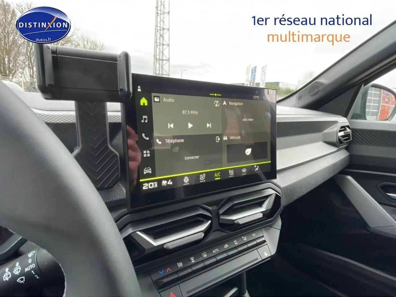 Vue intérieure du tableau de bord du Dacia Duster 2026 avec écran tactile central et commandes climatisation.